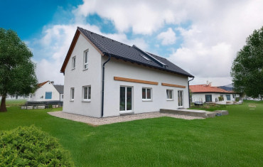 [Patrový dvojdům na klíč Haas, sedlová střecha, pohled zvenku, vchod na zahradu, zahrada.]