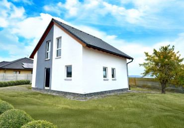 [Patrový rodinný dům Haas. Dřevostavba se sedlovou střechou a kamenným obkladem, se zahradou.]