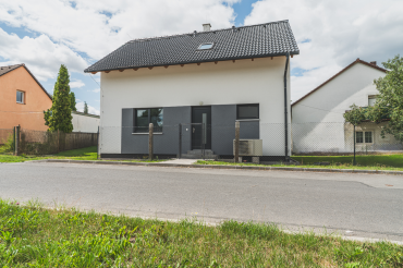 [Vzorový dům Haas, patrová dřevostavba, rodinný dům 5+kk se zahradou, pohled zepředu.]