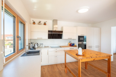 [Moderní kuchyně v patrové dřevostavbě na klíč od Haas. Světlý interiér.]