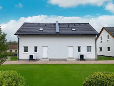 [Patrový dvojdům na klíč Haas, sedlová střecha, pohled zvenku, zahrada.]