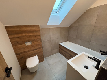 [Patrový dům na klíč Haas, moderní koupelna v přírodních tónech.]