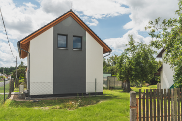[Vzorový dům Haas, patrová dřevostavba, rodinný dům se sedlovou střechou, 5+kk, zahrada, pohled z boku.]